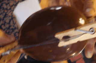 Molde relleno de chocolate sostenido por pinzas