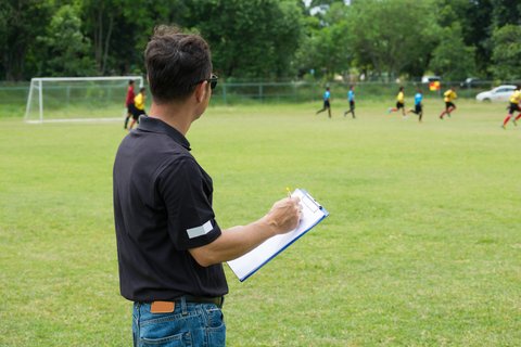 27084646_team-manager-coaching-his-crew-beside-football-or-soccer-field