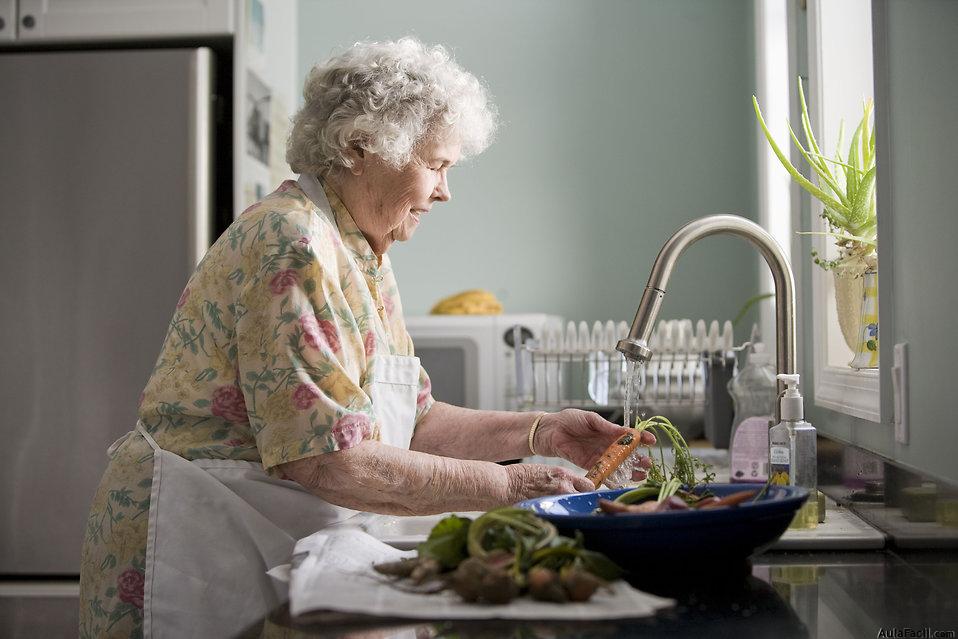 Mujer mayor trabajando en la cocina.