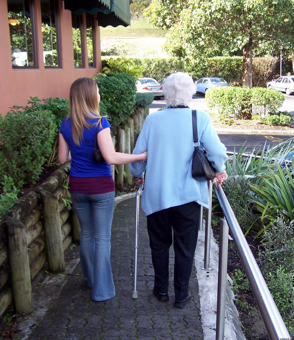 Anciana con demencia danto un paseo con su cuidadora.